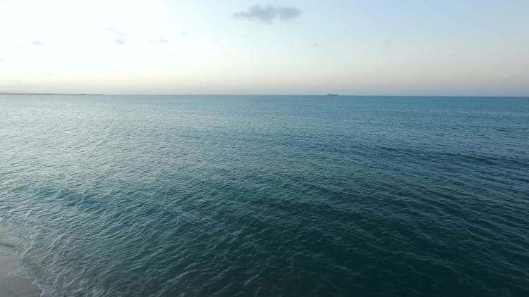 View of the ocean surface with a ship on the horizon