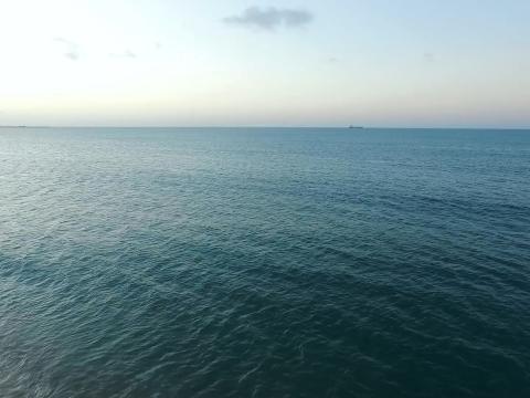 View of the ocean surface with a ship on the horizon